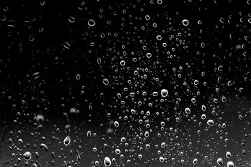 Fototapeta na wymiar Raindrops on black glass