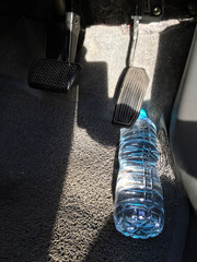 Water bottle getting stuck in the car accelerator and brake peddle demonstrating the danger of the...