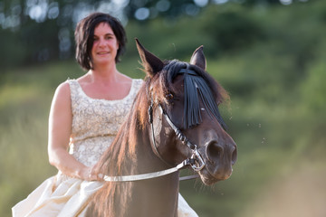 Fototapeta premium portrait of a woman with bridal dress and Andalusian horse