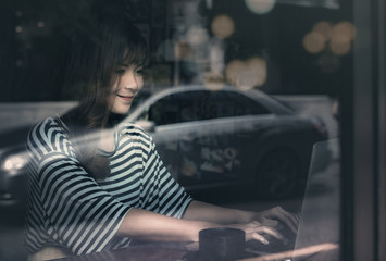 young woman using laptop in coffee shop