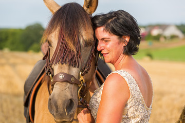 Obraz premium portrait of a woman with bridal dress and Andalusian horse