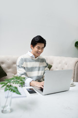 Asian young business man working with laptop atthe city cafe.