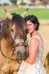 Fototapeta premium portrait of a woman with bridal dress and Andalusian horse