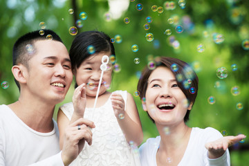 Young happy Asian family spending time together at the park.