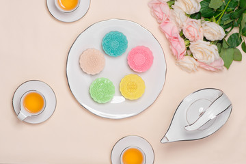 Sweet color of snow skin mooncake. Traditional mid autumn festival foods with tea on table setting.