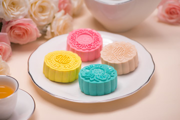 Sweet color of snow skin mooncake. Traditional mid autumn festival foods with tea on table setting.