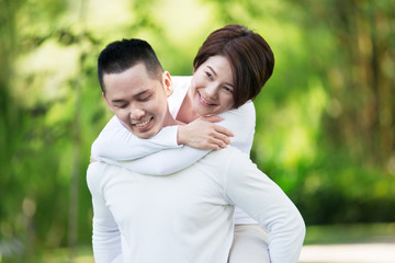 Young happy Asian couple spending time together at the park.