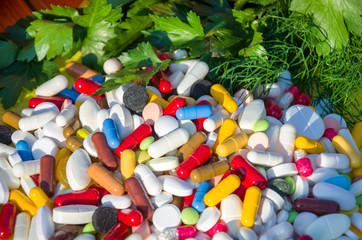 разноцветные таблетки на фоне зелени