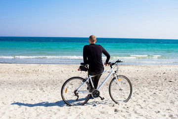 Fototapeta premium Bicycle rider relaxing on the beach in good weather 