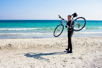 Fototapeta premium Bicycle rider relaxing on the beach in good weather 