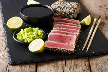 Sesame Seed Crusted Seared Tuna served with wasabi and sauce closeup. horizontal