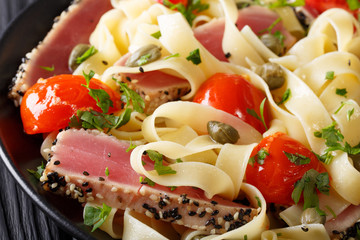 Pasta Fetuchini with tuna steak, tomatoes and capers macro. horizontal
