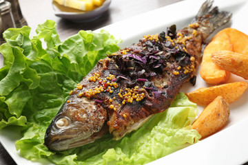 Plate with delicious fried fish, closeup