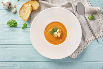 Plate with delicious carrot soup on table