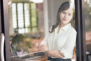 View of Through a glass window, Asian young business freelance w