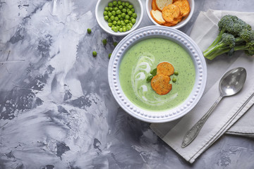 Composition with broccoli soup with rucks on grey background