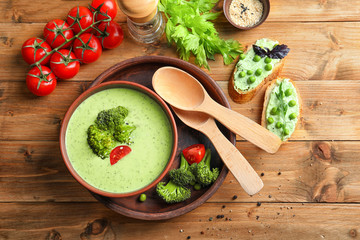 Composition with delicious broccoli soup on wooden table