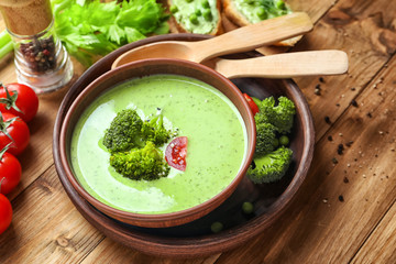 Bowl with delicious broccoli soup on table