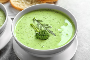 Bowl with delicious broccoli soup on table