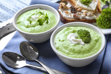 Bowls with delicious creamy broccoli soup on tray