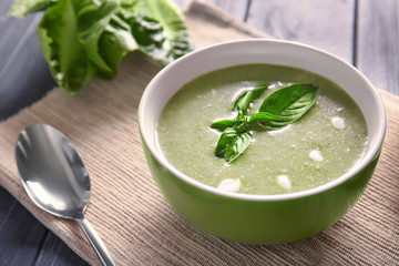 Bowl with fresh kale soup on table