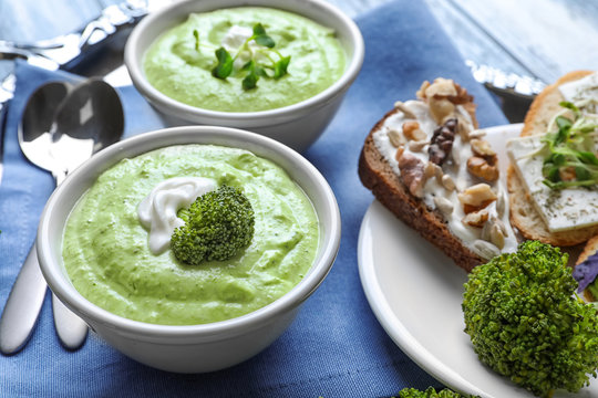 Bowls with delicious creamy broccoli soup on tray