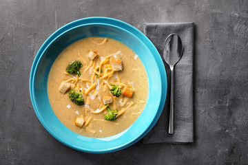 Plate with broccoli cheddar soup on table