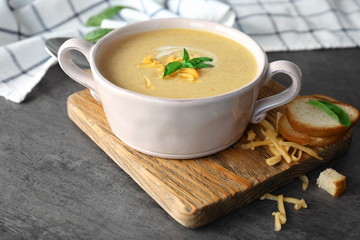 Broccoli cheddar soup in bowl on wooden board
