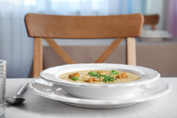 Plate with broccoli cheddar soup on kitchen table