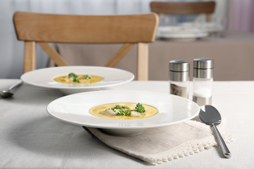 Plates with broccoli cheddar soup on kitchen table