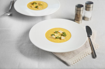 Plate with broccoli cheddar soup on kitchen table