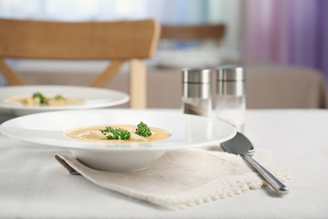 Plate with broccoli cheddar soup on kitchen table