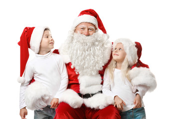 Cute kids in Christmas hats and authentic Santa Claus on white background