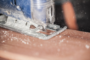 wood cutting with jigsaw, close up on the blade 