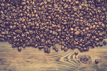 Roasted coffee beans background, black coffee's grain on wooden table