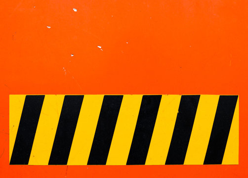 Texture Of Orange Flat Metal Plate With Black And Yellow Safety Sticker, Part Of Electric Service Truck, Old And Dusty