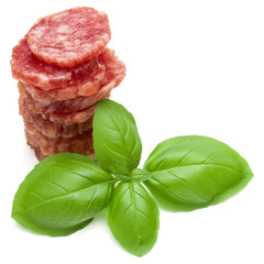 Salami smoked sausage slices and basil leaves isolated on white background cutout
