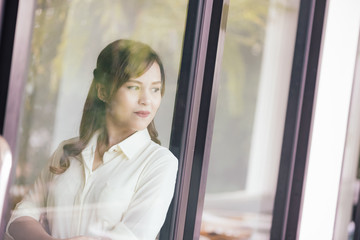 View of Through a glass window, Asian girl business thinking ide