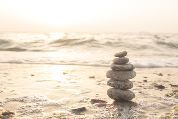 Stones balance on beach in sunrise light 