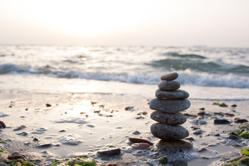 Stones balance on beach in sunrise light 