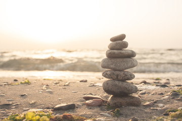Stones balance on beach in sunrise light 