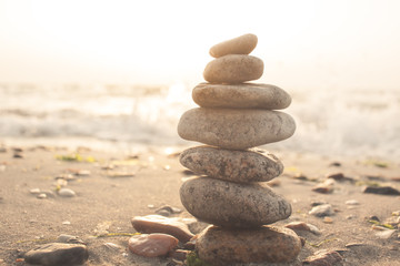 Stones balance on beach in sunrise light 