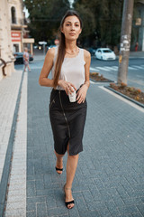 Beautiful brunette young woman walking through the streets of Old City. Fashion concept