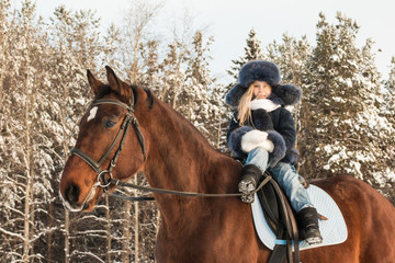 Obraz premium Small girl and horse in a winter