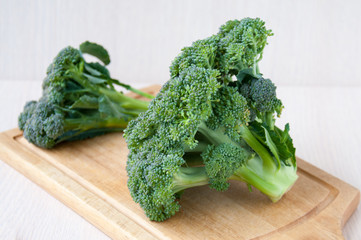 Big and small head of broccoli on a wooden board