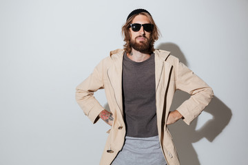 Bearded hipster man wearing sunglasses standing isolated