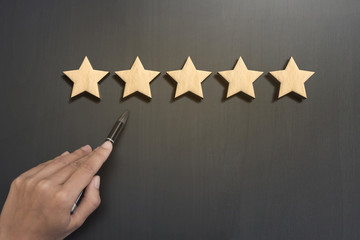 Business hand select five star rating on wooden. concept customer service excellent