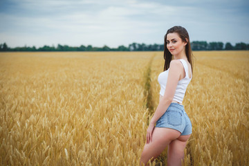 Beautiful woman girl looking at camera. close-up to very beautiful girl with amazing green eyes red lips and attractive face. cute amazing portrait in the field of wheat. birthmark on the face