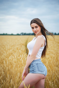 Beautiful woman girl looking at camera. close-up to very beautiful girl with amazing green eyes red lips and attractive face. cute amazing portrait in the field of wheat. birthmark on the face