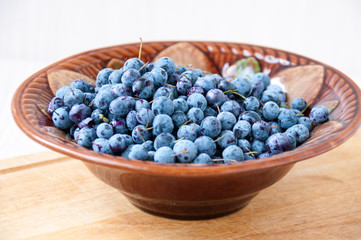 Berry blueberries in a ceramic bowl on table